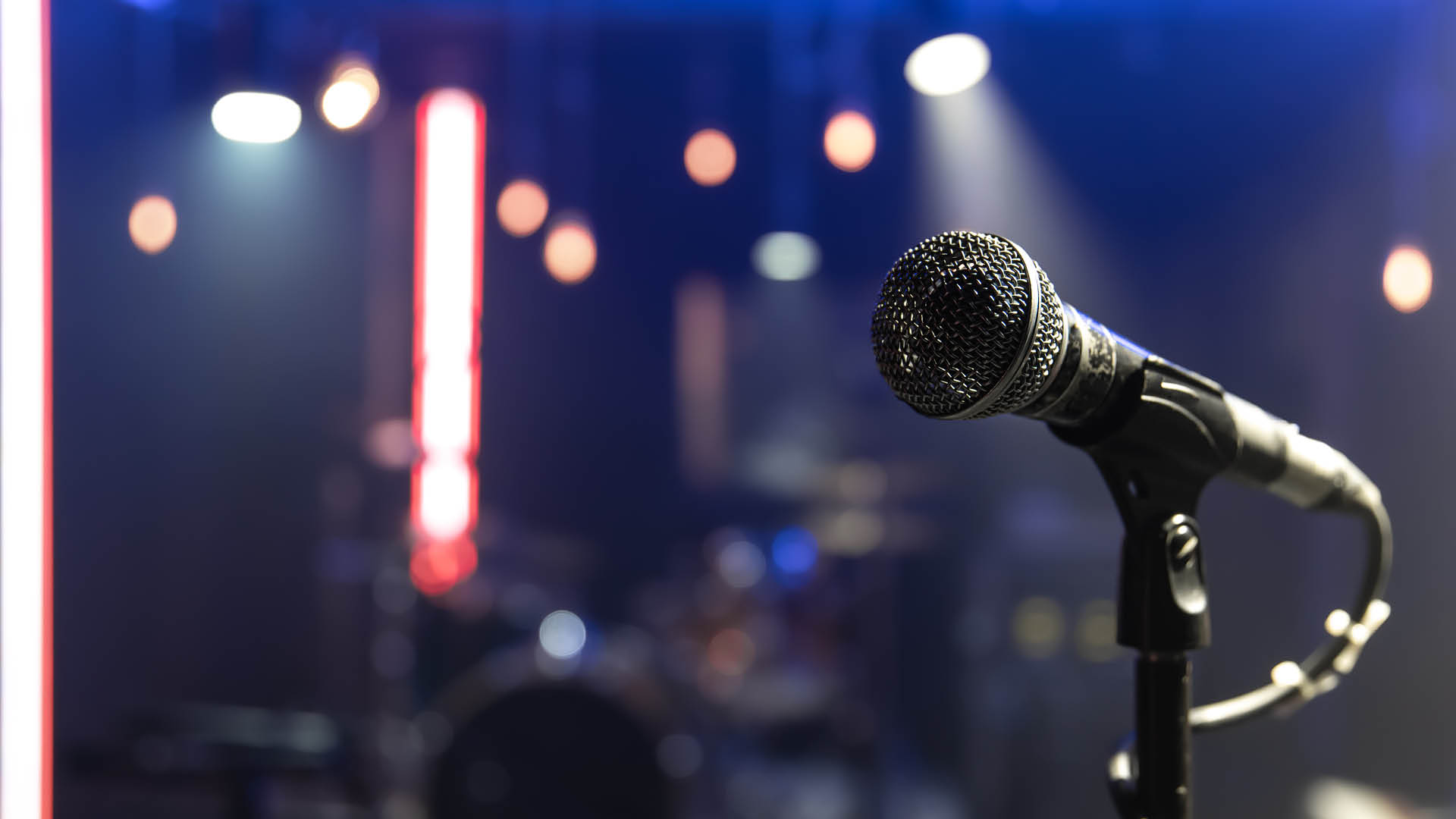 Close up of a microphone on a concert stage with beautiful lighting.