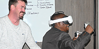 Prof Michael Temane, deputy registrar, enjoys a game of rugby while being assisted by Russel Millen, consultant from Innovado. Innovado is the company that assisted in developing the technology for the VR simulation laboratory.