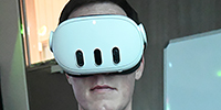 Neville Robertson, researcher and innovator, illustrates how to use a VR headset.